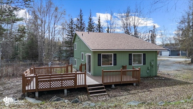 back of property featuring a deck and a shingled roof