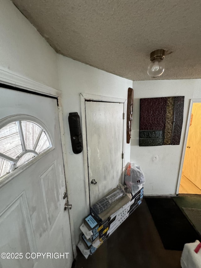 foyer entrance with a textured ceiling