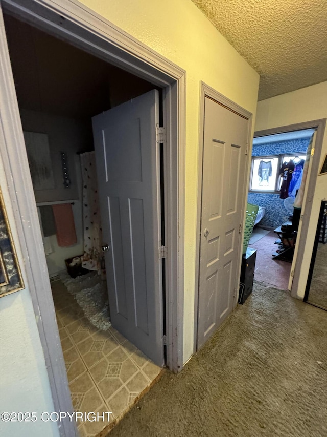 hallway featuring carpet floors and a textured ceiling