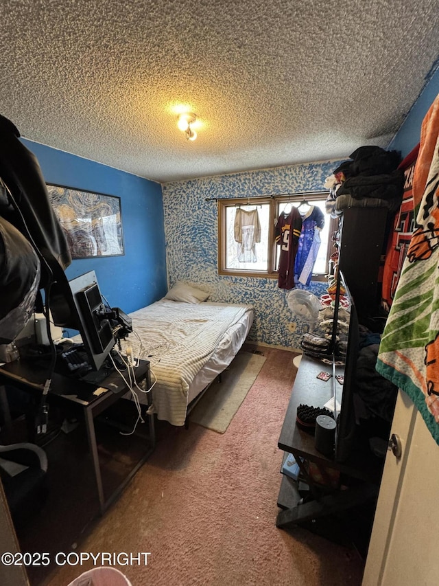 bedroom with wallpapered walls, a textured ceiling, and carpet floors