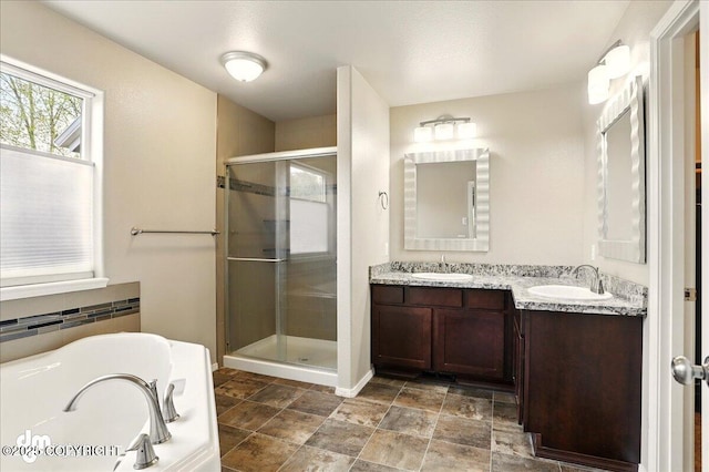 full bathroom with a stall shower, a bath, double vanity, stone finish floors, and baseboards