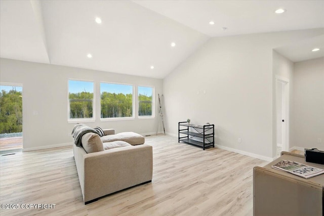 living room featuring recessed lighting, vaulted ceiling, a wealth of natural light, and light wood-style floors