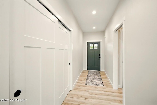 doorway featuring recessed lighting, baseboards, and light wood finished floors
