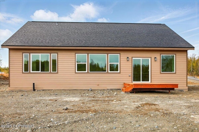 back of house with roof with shingles