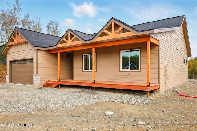 view of front of house featuring a porch, an attached garage, board and batten siding, and roof with shingles