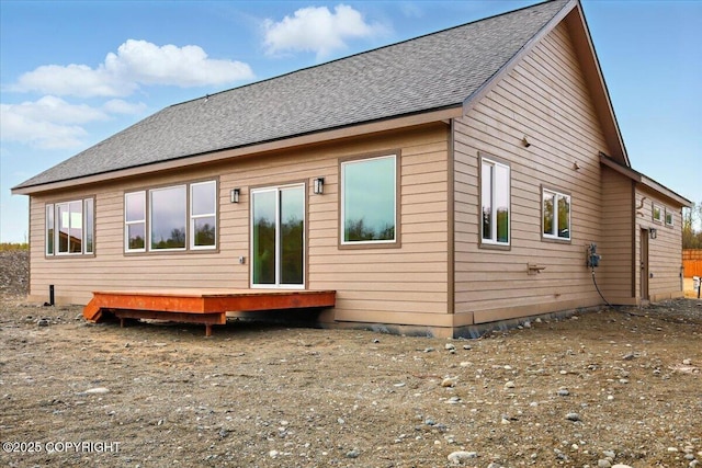 back of property featuring roof with shingles