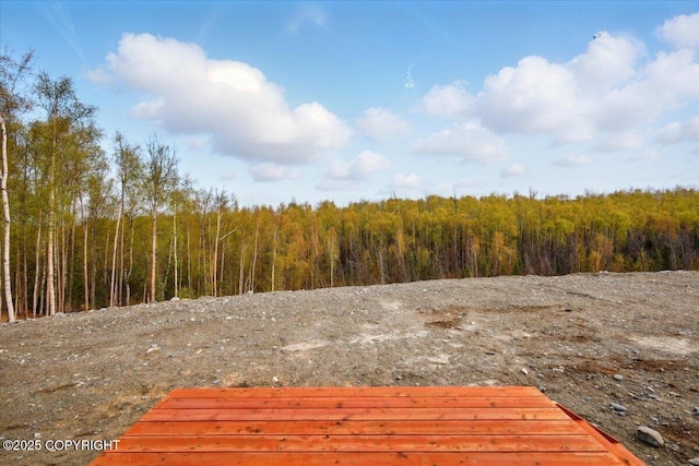 wooden terrace featuring a wooded view