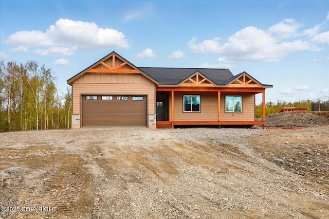 view of front of house with dirt driveway, board and batten siding, covered porch, and a garage