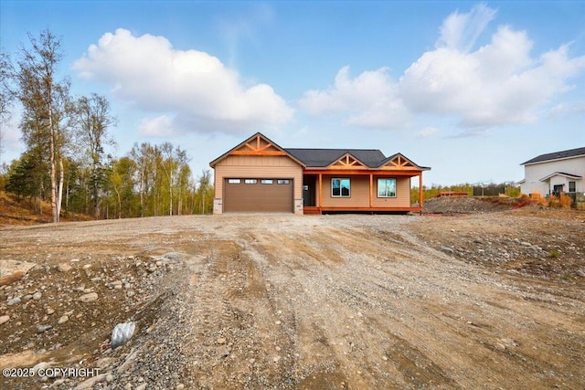 chalet / cabin featuring an attached garage and dirt driveway