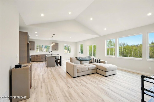 living room with recessed lighting, baseboards, light wood-style flooring, and lofted ceiling