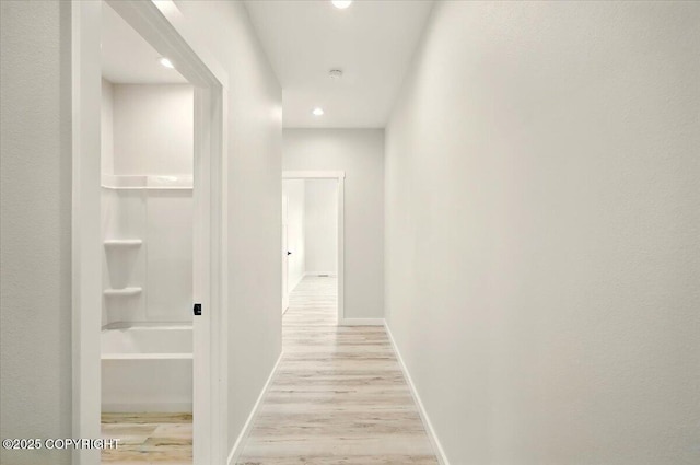 hallway with baseboards, recessed lighting, and light wood finished floors