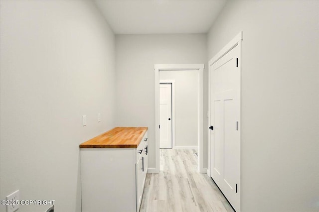 hallway with baseboards and light wood-style floors