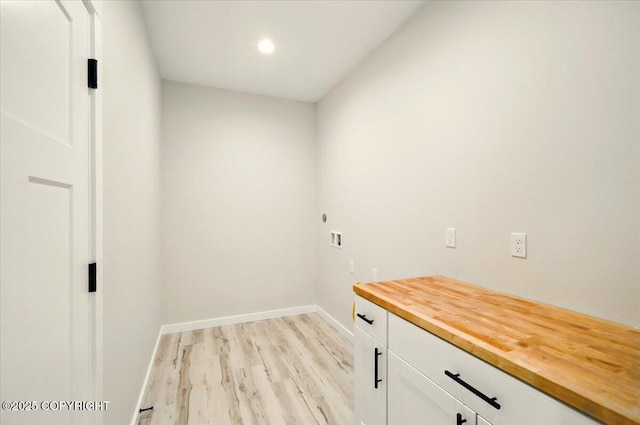 clothes washing area featuring baseboards, recessed lighting, cabinet space, washer hookup, and light wood finished floors
