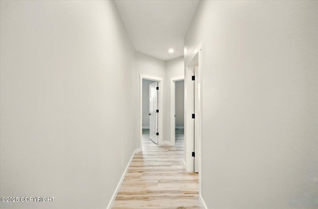 corridor with baseboards, recessed lighting, and light wood-style flooring
