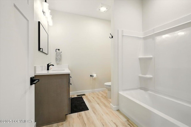 bathroom with vanity, baseboards, wood finished floors, and toilet