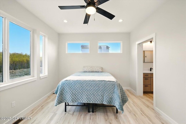bedroom with baseboards, ensuite bathroom, and light wood finished floors