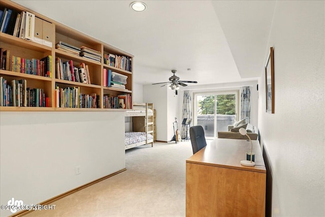 office featuring light colored carpet, a ceiling fan, and baseboards