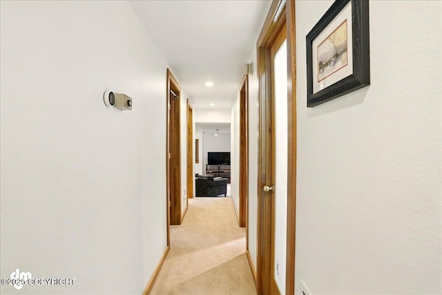hallway featuring light carpet, recessed lighting, and baseboards