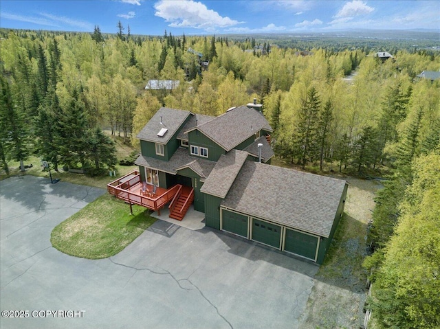 aerial view of property and surrounding area with a forest