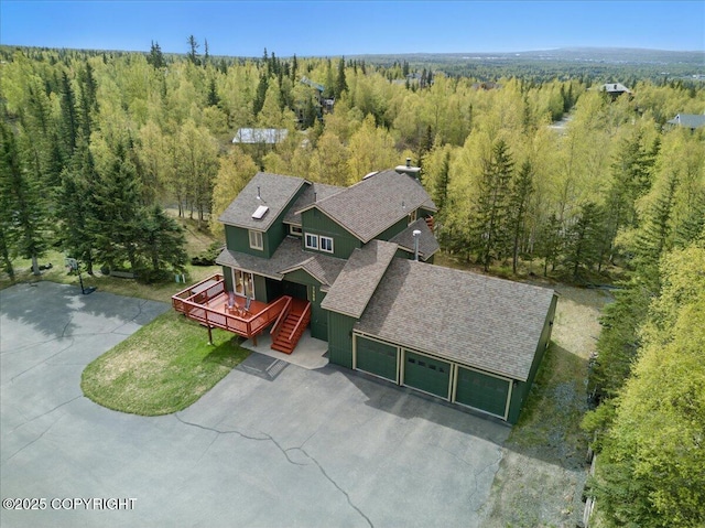 aerial view of property and surrounding area featuring a forest