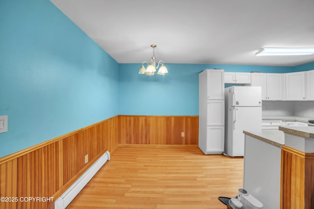 8515 Jewel Lake Rd # 25, Anchorage, AK 99502 - kitchen with freestanding refrigerator, baseboard heating, wainscoting, light wood-style floors, and a chandelier