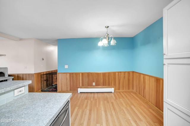 8515 Jewel Lake Rd # 25, Anchorage, AK 99502 - kitchen featuring baseboard heating, wainscoting, light wood-style flooring, a chandelier, and light countertops