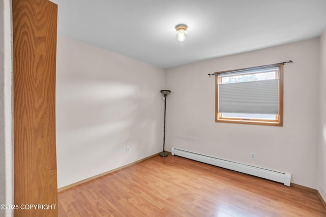 8515 Jewel Lake Rd # 25, Anchorage, AK 99502 - empty room featuring a baseboard heating unit, light wood-style flooring, and baseboards