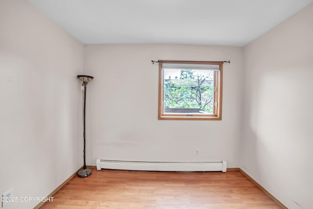 8515 Jewel Lake Rd # 25, Anchorage, AK 99502 - empty room with a baseboard heating unit, light wood-style floors, and baseboards