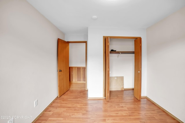 8515 Jewel Lake Rd # 25, Anchorage, AK 99502 - unfurnished bedroom with light wood-type flooring, a closet, and baseboards