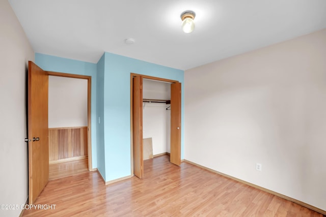 8515 Jewel Lake Rd # 25, Anchorage, AK 99502 - unfurnished bedroom featuring light wood-style floors, a closet, and baseboards