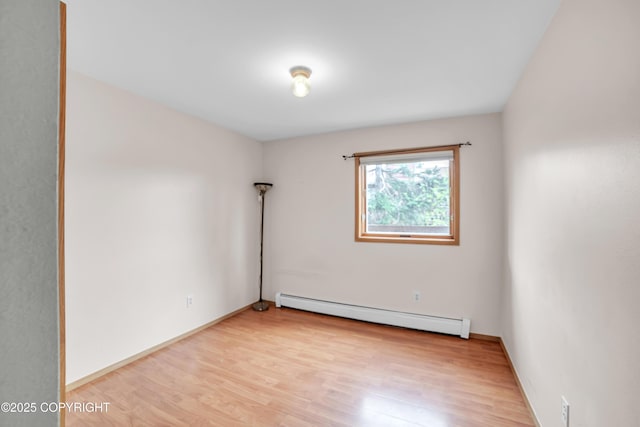 8515 Jewel Lake Rd # 25, Anchorage, AK 99502 - unfurnished room with a baseboard heating unit, light wood-type flooring, and baseboards