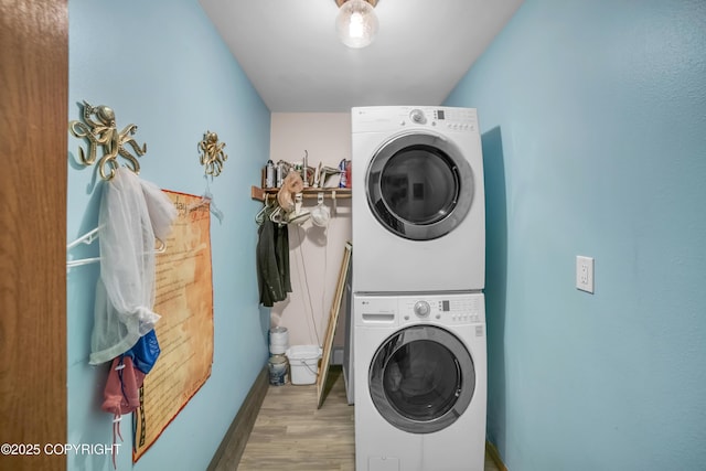 8515 Jewel Lake Rd # 25, Anchorage, AK 99502 - washroom featuring estacked washer and dryer, wood finished floors, and baseboards