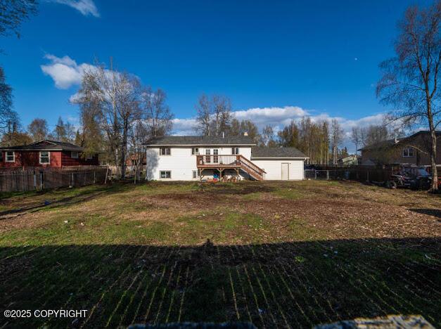 back of property with stairway, a wooden deck, an outbuilding, and a storage unit