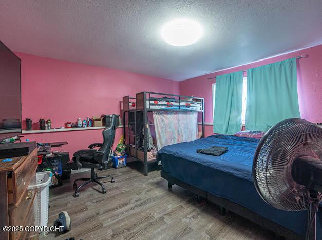 bedroom featuring wood finished floors and a textured ceiling