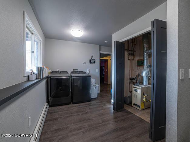 washroom with independent washer and dryer, baseboard heating, dark wood finished floors, a textured wall, and a heating unit