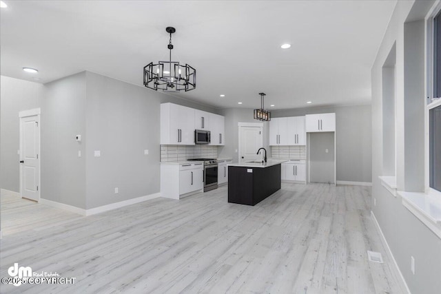 kitchen with stainless steel appliances, a chandelier, decorative backsplash, light wood-type flooring, and white cabinets