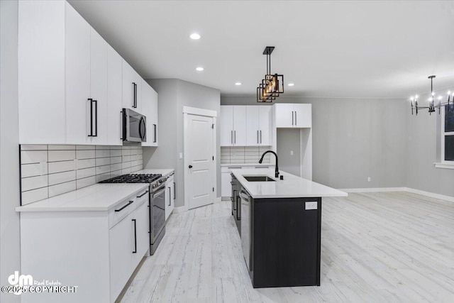 kitchen with stainless steel appliances, a sink, tasteful backsplash, light wood finished floors, and recessed lighting