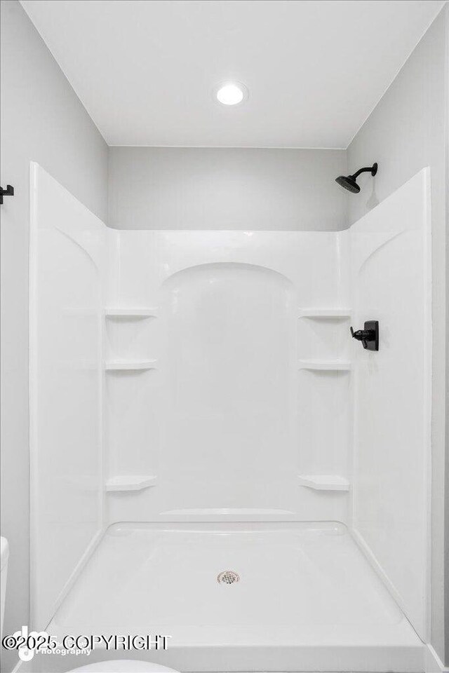 bathroom featuring a shower and toilet