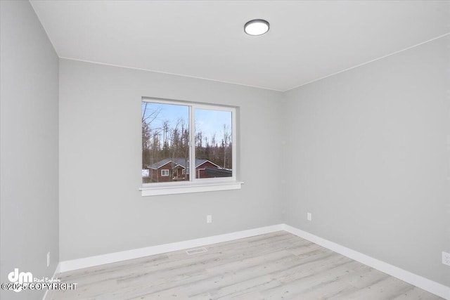 spare room with wood finished floors and baseboards