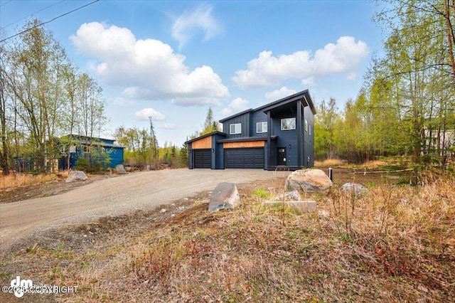contemporary home featuring dirt driveway and a garage