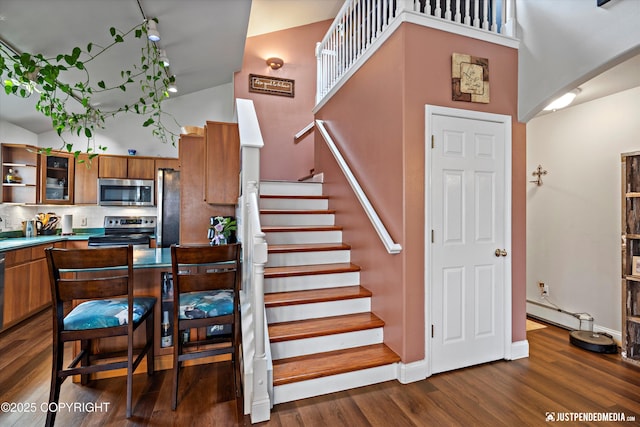 6801 E Tudor Rd, Anchorage, AK 99507 - stairs with baseboards, arched walkways, a towering ceiling, and wood finished floors