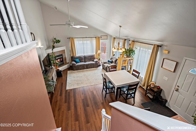 6801 E Tudor Rd, Anchorage, AK 99507 - dining space featuring dark wood-style floors, ceiling fan, vaulted ceiling, and a tile fireplace