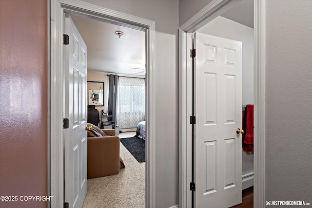 6801 E Tudor Rd, Anchorage, AK 99507 - hallway featuring a baseboard radiator and a textured wall