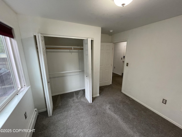 123 E 24th Ave # 4, Anchorage, AK 99503 - unfurnished bedroom with a baseboard heating unit, dark carpet, and a closet