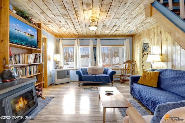 13706 E First St, Talkeetna, AK 99676 - living area featuring wood ceiling, radiator heating unit, wooden walls, wood finished floors, and a lit fireplace