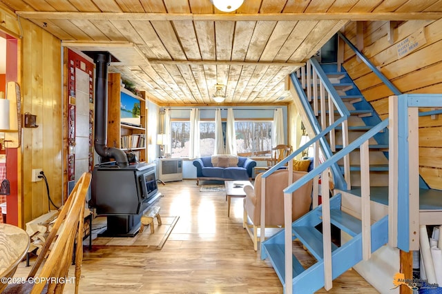 13706 E First St, Talkeetna, AK 99676 - living area featuring a wood stove, wooden ceiling, stairs, wooden walls, and wood finished floors