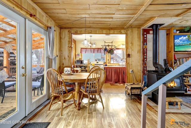 13706 E First St, Talkeetna, AK 99676 - dining area with a wood stove, wood ceiling, wood finished floors, wood walls, and a chandelier