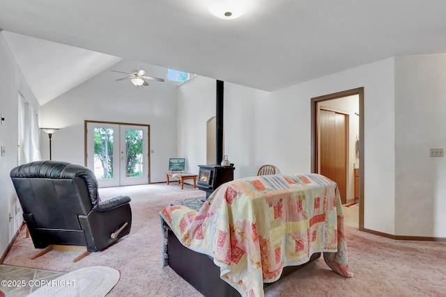 2643 S Rory Cir, Big Lake, AK 99654 - living area with light colored carpet, a wood stove, ceiling fan, vaulted ceiling, and baseboards