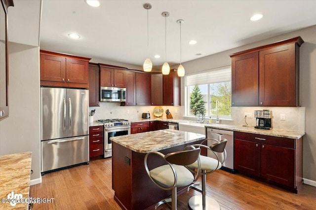 18627 Mountain Plover Cir, Anchorage, AK 99516 - kitchen with appliances with stainless steel finishes, tasteful backsplash, wood finished floors, recessed lighting, and hanging light fixtures