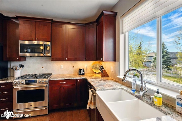 18627 Mountain Plover Cir, Anchorage, AK 99516 - kitchen with stainless steel appliances, backsplash, dark wood-style flooring, and light stone counters